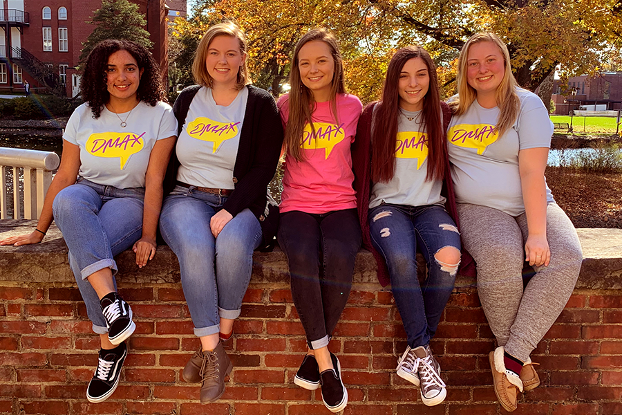 five girls sitting on a wall